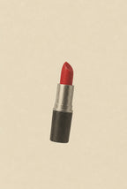 Single tube of red lipstick on cream, cinematic grain. Femme art print by Drunk Dame.