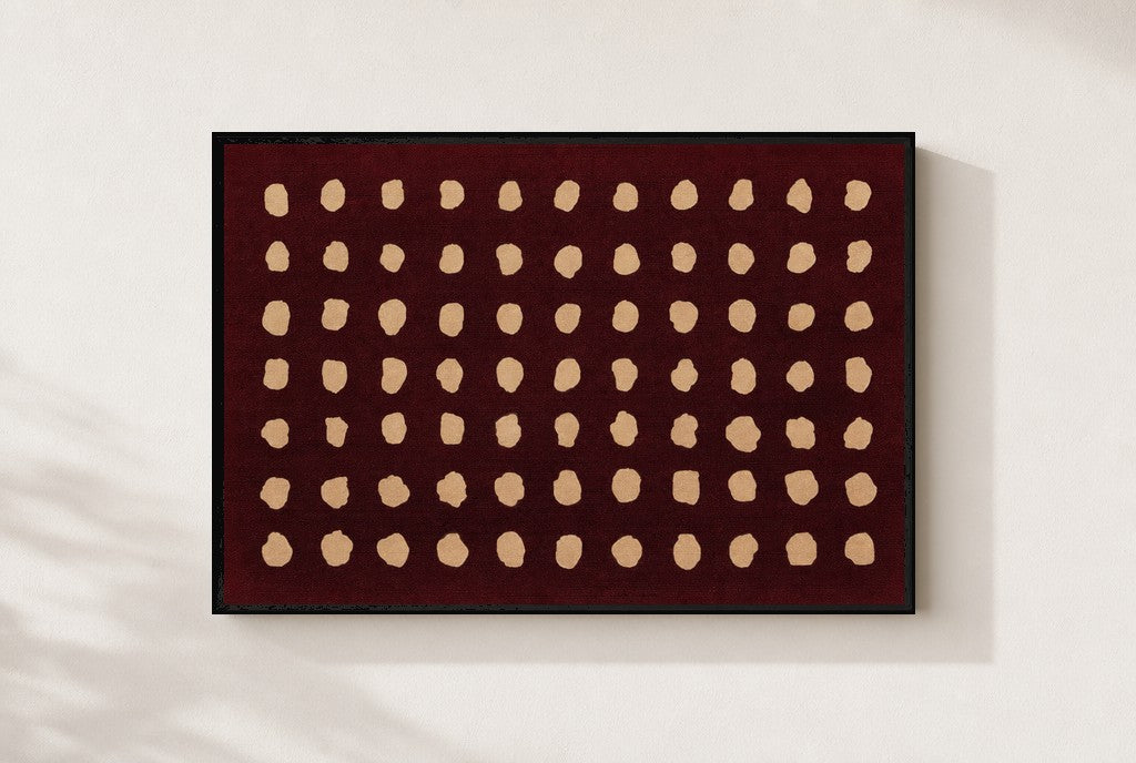 Cream Dots, Oxblood print, mounted in a black wood frame on a cream wall.