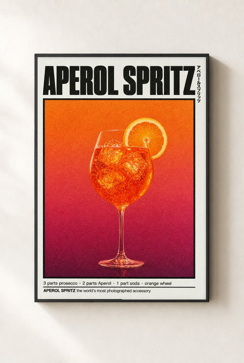 Aperol Spritz print, mounted in a black wood frame on a cream wall.