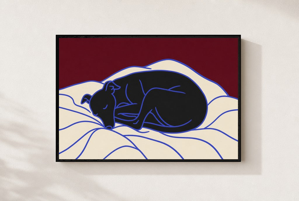 Sleeping Greyhound print, mounted in a black wood frame on a cream wall.