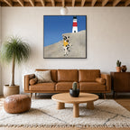 Framed Yellow at the Lighthouse hung above a mid-century walnut console with ceramics.