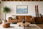 Framed Three in the Waves hung above a mid-century walnut console with ceramics.