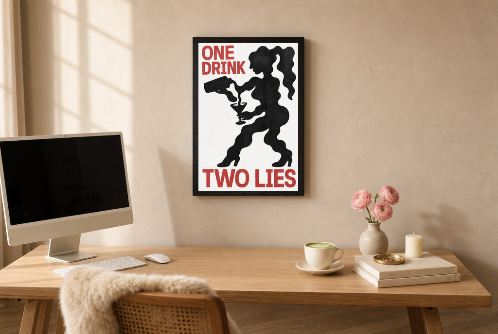 Framed One Drink, Two Lies hung above a mid-century walnut console with ceramics.