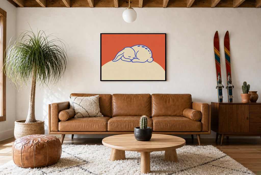 Framed Sleeping Bunny hung above a mid-century walnut console with ceramics.