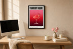 Framed Strawberry Daiquiri hung above a mid-century walnut console with ceramics.