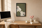 Framed Two Rabbits, Olive hung above a mid-century walnut console with ceramics.