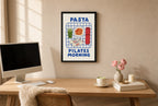 Framed Pasta Pilates Morning hung above a mid-century walnut console with ceramics.