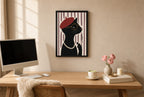Framed Cat, Red Beret hung above a mid-century walnut console with ceramics.