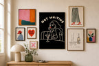 Not Waiting mixed into a layered gallery wall of varied frame sizes.
