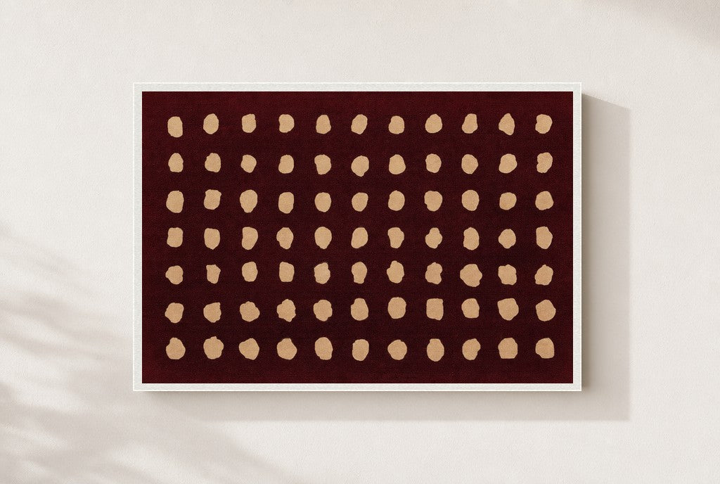 Cream Dots, Oxblood print, mounted in a white wood frame on a cream wall.