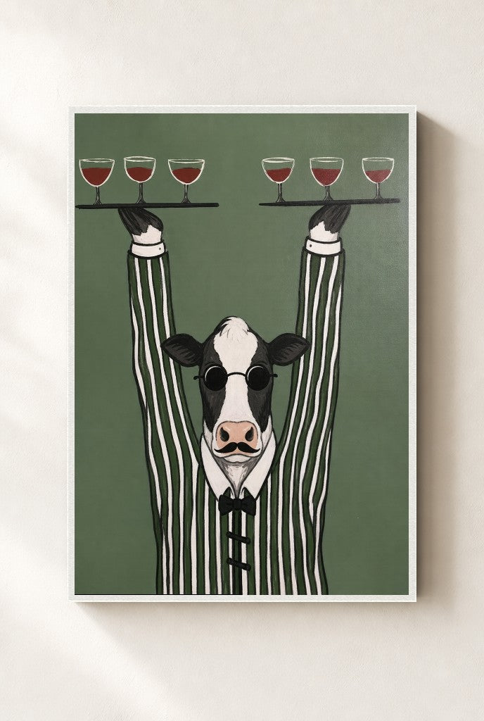 Pour Cow print, mounted in a white wood frame on a cream wall.