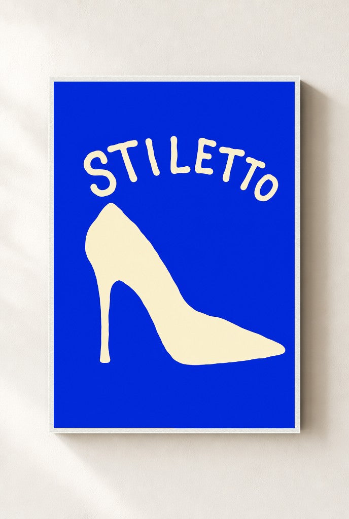 Stiletto print, mounted in a white wood frame on a cream wall.