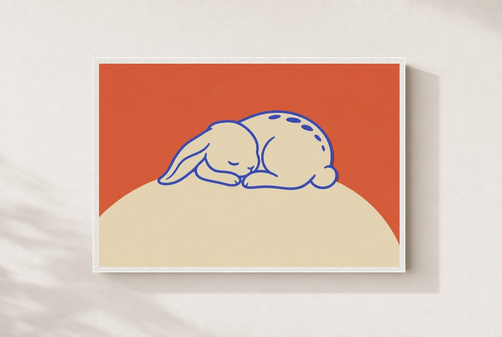 Sleeping Bunny print, mounted in a white wood frame on a cream wall.