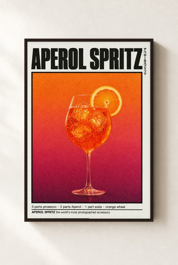 Aperol Spritz print, mounted in a walnut wood frame on a cream wall.
