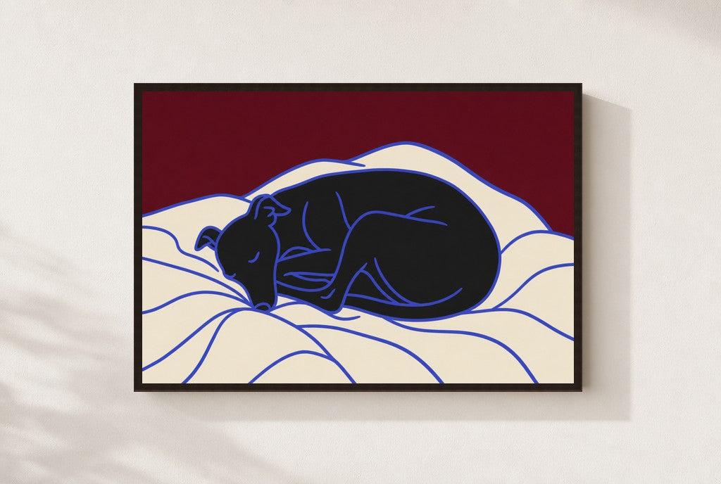 Sleeping Greyhound print, mounted in a walnut wood frame on a cream wall.